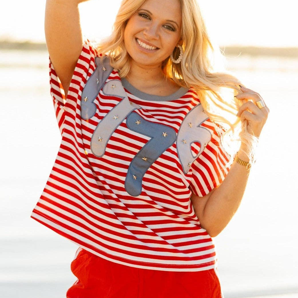 a high-stretch oversized short-sleeve stripe top with a crew neckline, a horizontal stripe pattern (red and white), bold denim 1776 patch detail, tiny star accents, a relaxed easy drape, and unlined