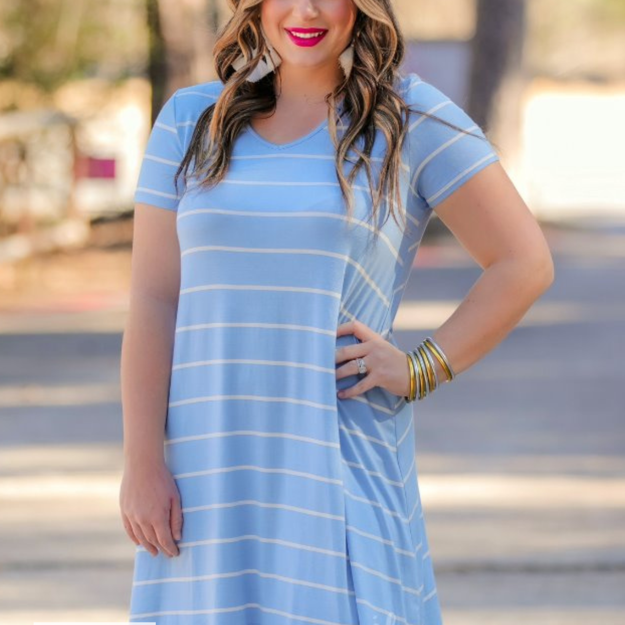 a soft stretchy knit dress with a V-neckline, short sleeves, a relaxed A-line silhouette, a straight hemline, and a horizontal white stripe pattern on a solid chambray background with a MADE IN USA watermark in the bottom left hand corner