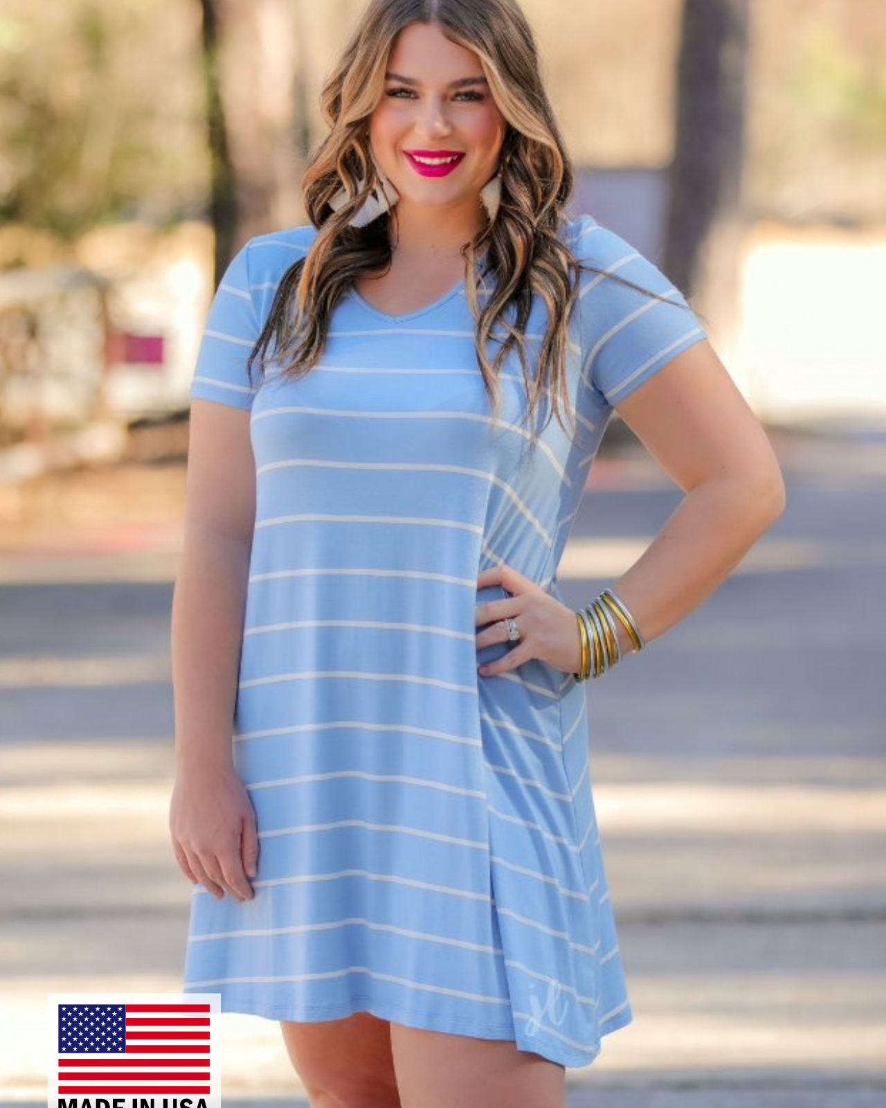 a soft stretchy knit dress with a V-neckline, short sleeves, a relaxed A-line silhouette, a straight hemline, and a horizontal white stripe pattern on a solid chambray background with a MADE IN USA watermark in the bottom left hand corner