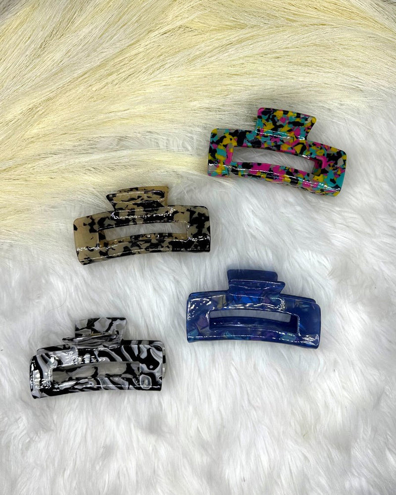 a marble acrylic claw clip with a gentle grip that reduces breakage while providing a secure hold in blue, multi, tan and white