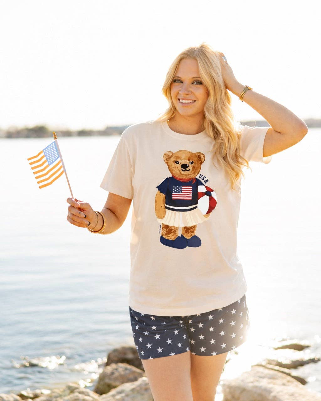 a relaxed-fit beige crew neck tee with a patriotic DTF teddy graphic, short sleeves, standard t-shirt length, unlined construction, and a little stretch that runs large