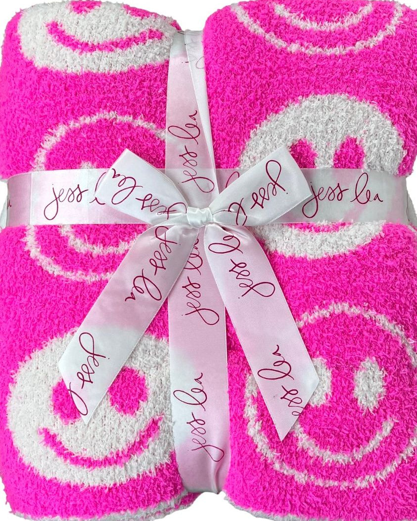 ultra-soft reversible throw on a pink and white happy face pattern print fabric in pink