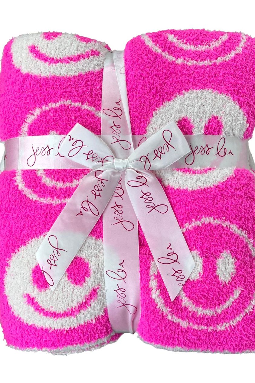 ultra-soft reversible throw on a pink and white happy face pattern print fabric in pink