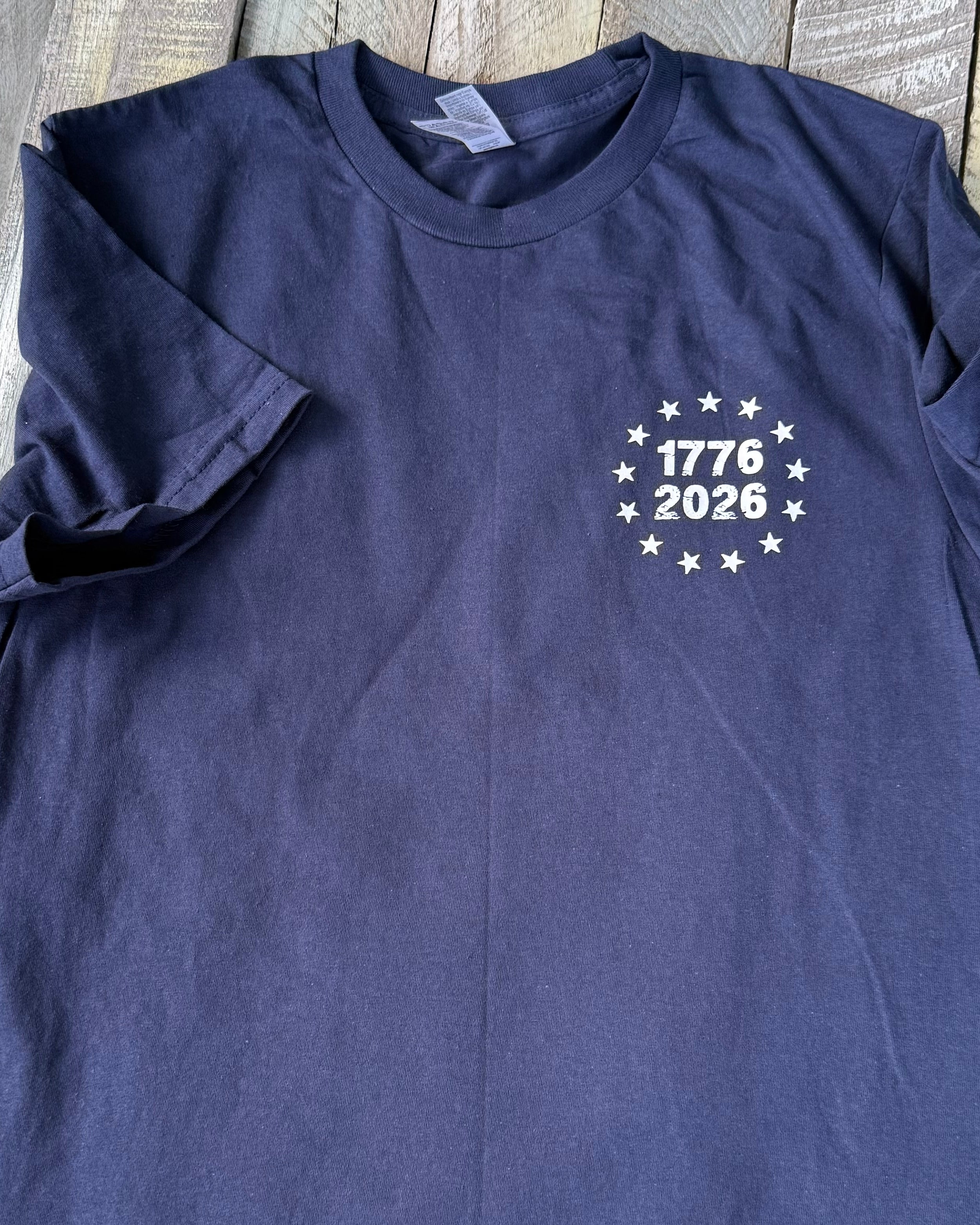 a soft navy unisex Gildan t-shirt with a crew neckline, short sleeves, a front 1776 / 2026 star circle graphic, a bold American flag and 250 YEARS Quarter-Millenial back design, and an easy year-round fit