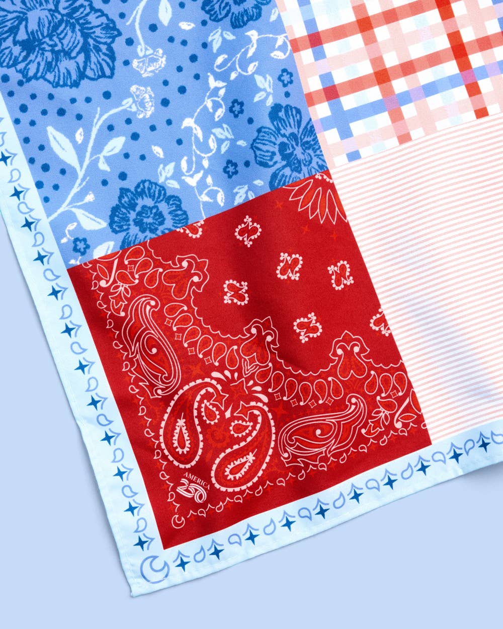 a soft silky polyester scarf with a red, white, and blue quilt-inspired print, finished with a blend of floral, gingham, and paisley details