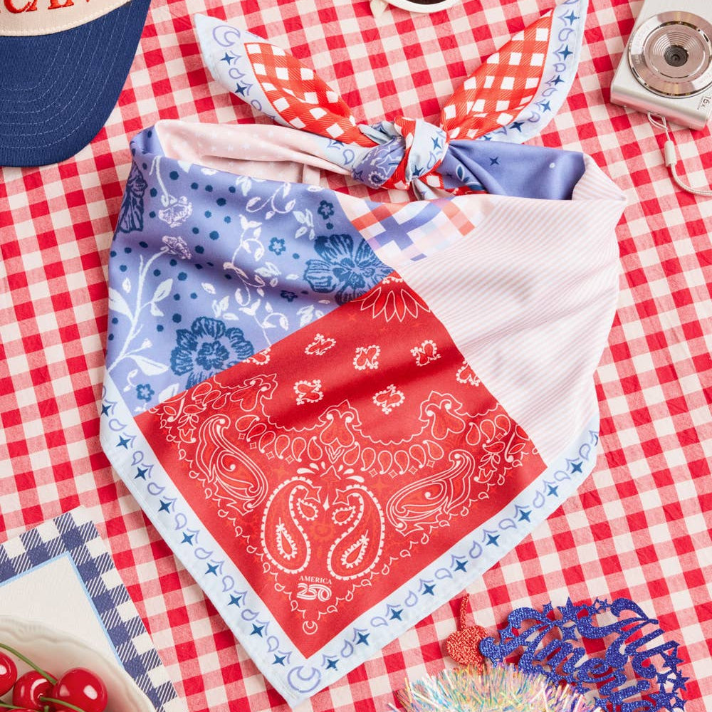 a soft silky polyester scarf with a red, white, and blue quilt-inspired print, finished with a blend of floral, gingham, and paisley details