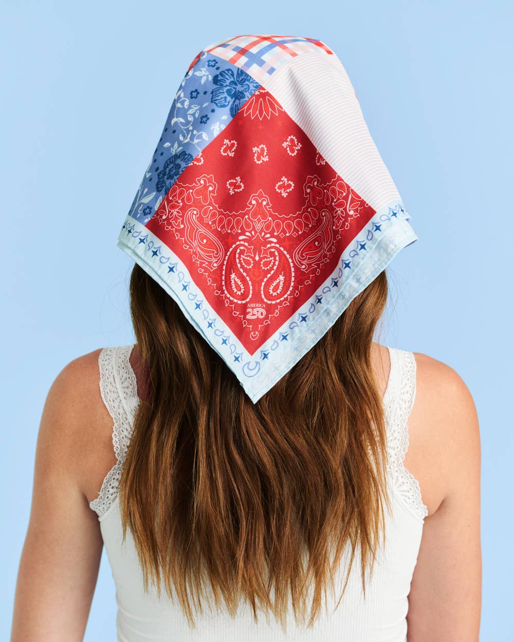 a soft silky polyester scarf with a red, white, and blue quilt-inspired print, finished with a blend of floral, gingham, and paisley details