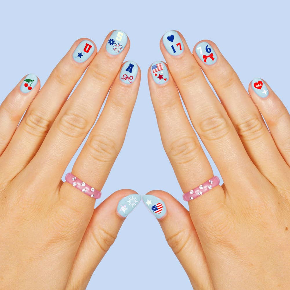 four complete sheets of peel-and-stick nail art with premium CMYK color, iridescent foil, and patriotic icons (bows, cherries, fireworks, flags, hearts, stars, and USA accents)