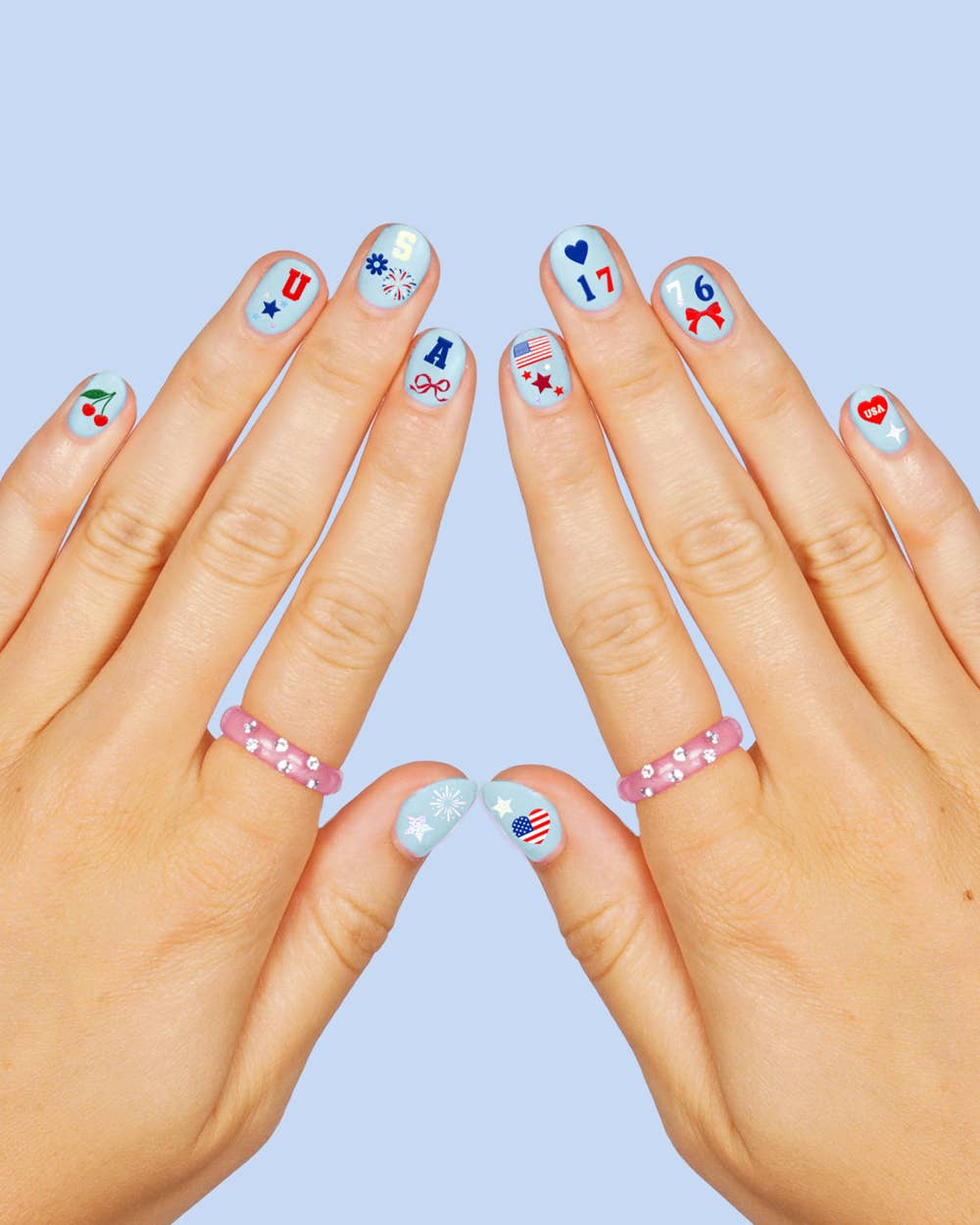 four complete sheets of peel-and-stick nail art with premium CMYK color, iridescent foil, and patriotic icons (bows, cherries, fireworks, flags, hearts, stars, and USA accents)