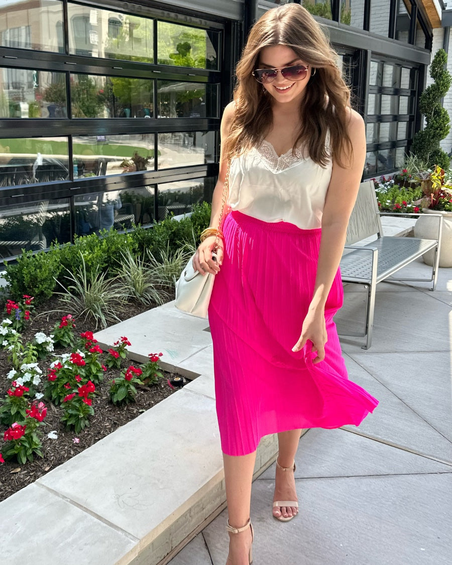 a vibrant pink midi skirt with an elastic waistband, a graceful pleated design, and an interior lining slip