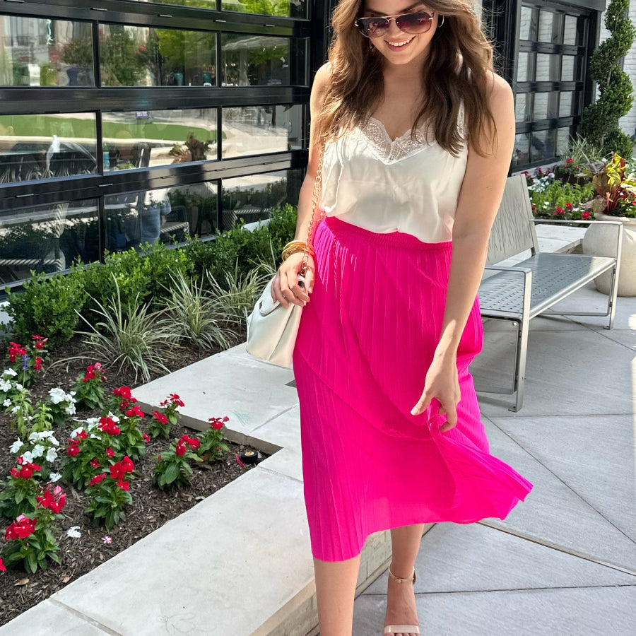 a vibrant pink midi skirt with an elastic waistband, a graceful pleated design, and an interior lining slip