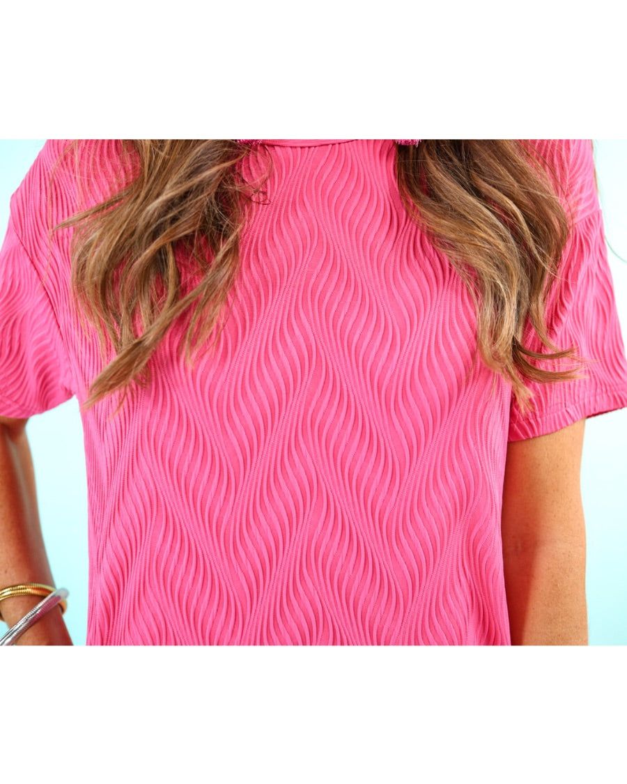pink short sleeve round neckline textured dress with side pockets and a rounded hemline