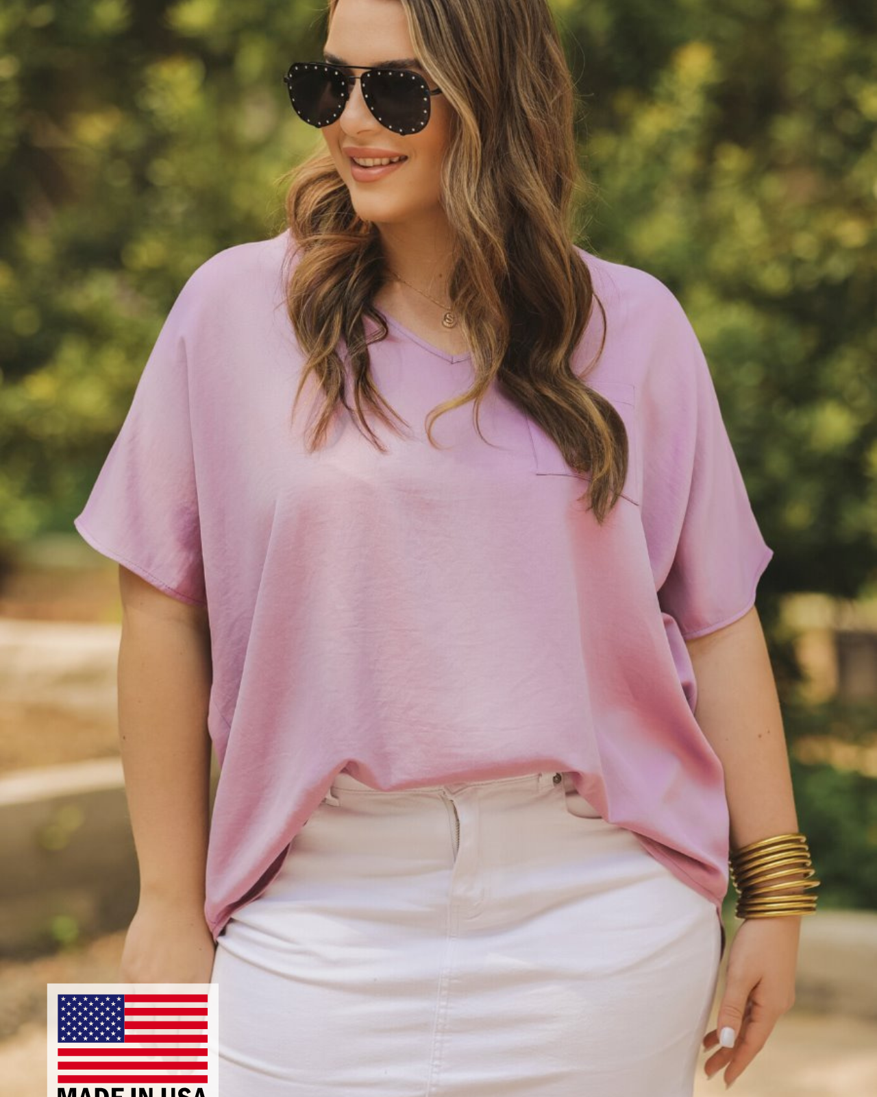 a lightweight lilac short-sleeve woven tunic with a V-neckline, a front chest pocket, and a relaxed, non-stretch silhouette, accented with a MADE IN USA watermark in the bottom left-hand corner