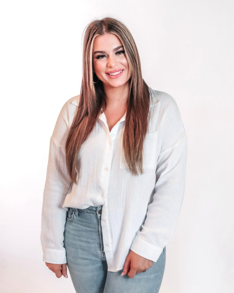 white lightweight button-up gauze top with a collared neckline, breezy sleeves, chest pocket, and a relaxed round-hem silhouette