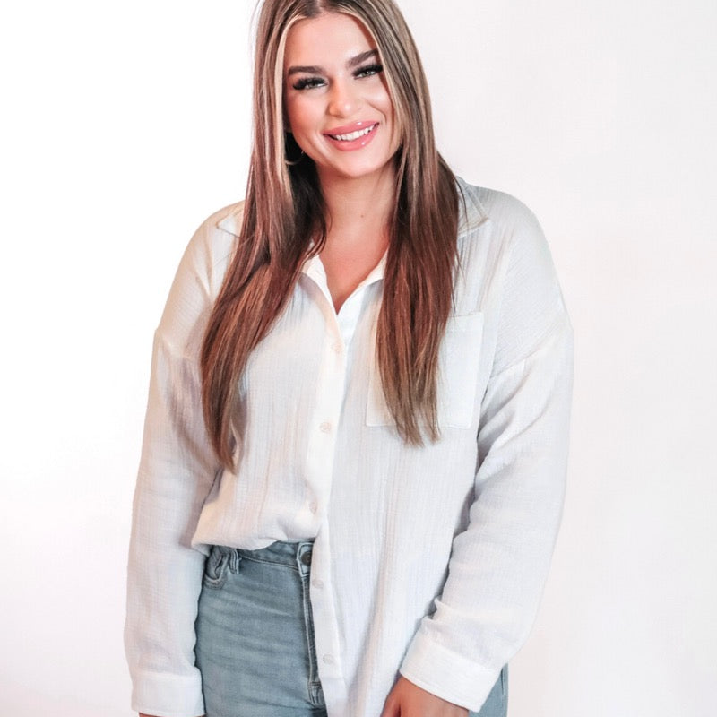 white lightweight button-up gauze top with a collared neckline, breezy sleeves, chest pocket, and a relaxed round-hem silhouette