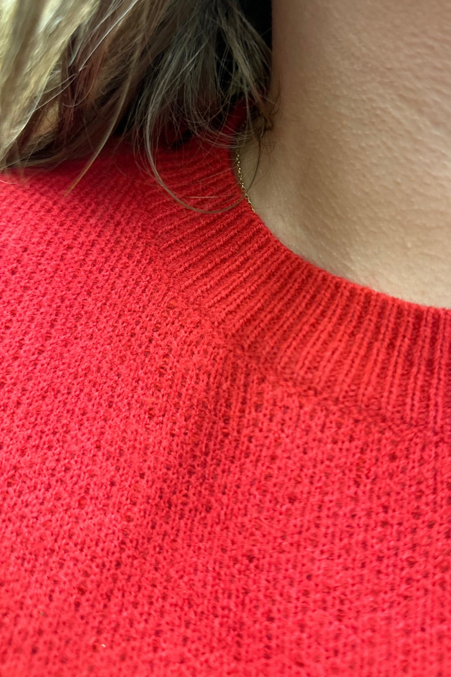 a red long-sleeve patterned sweater adorned with 'merry' script across the chest in white and ribbed detailing at the cuffs, neckline, and hem