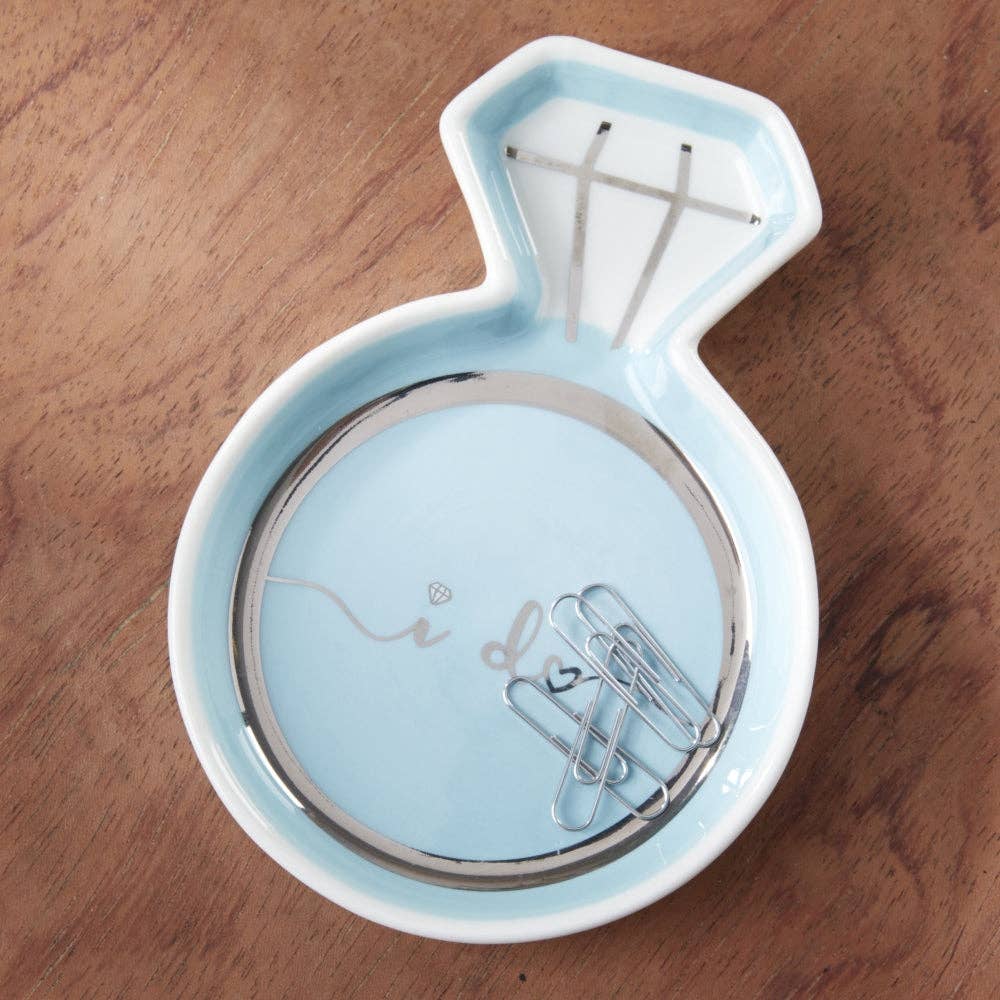 Light blue ring dish with 'I do' text on a wooden surface