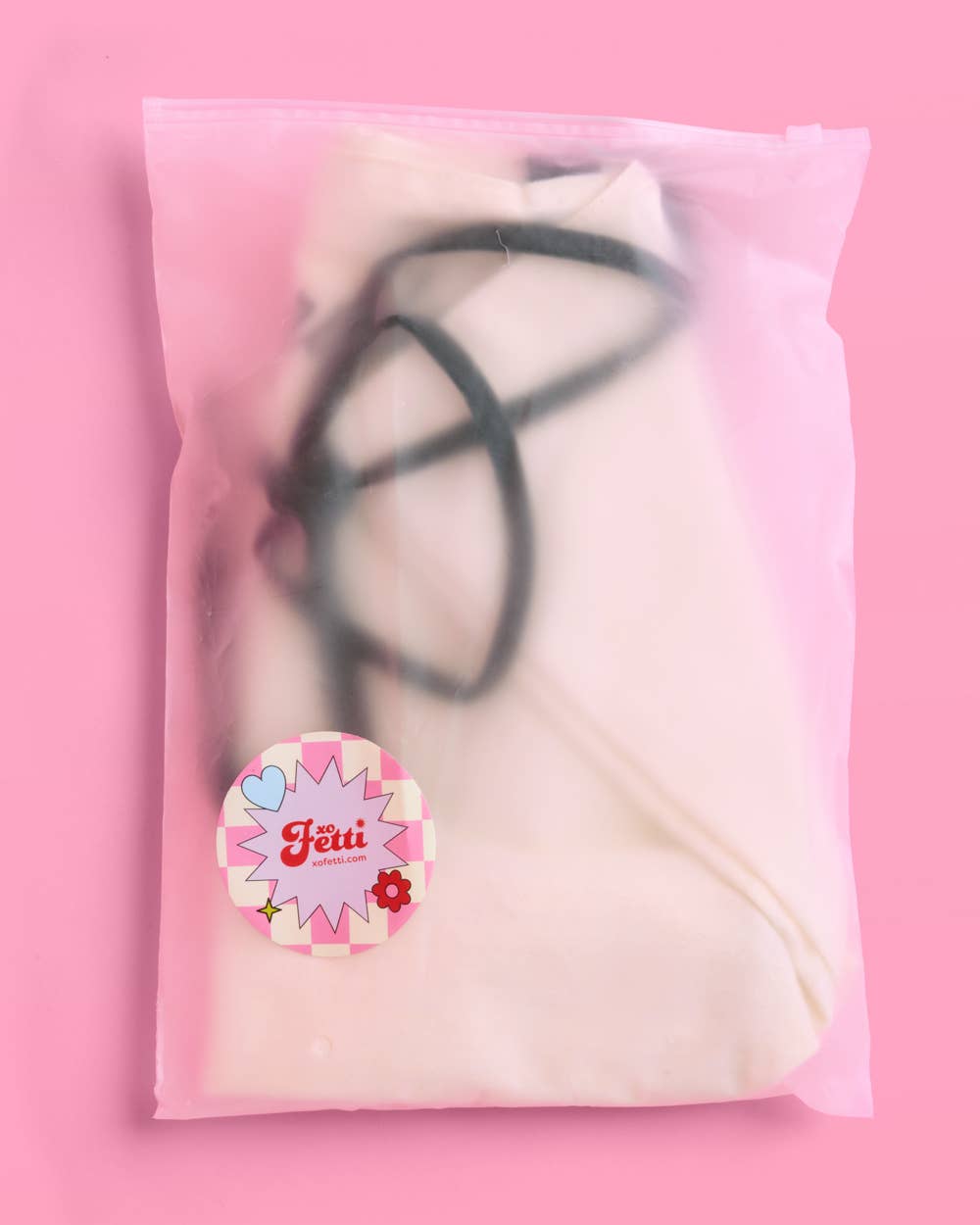 a roomy cream canvas tote with black embroidered 'Bride' script, black shoulder straps, and bow tie detail