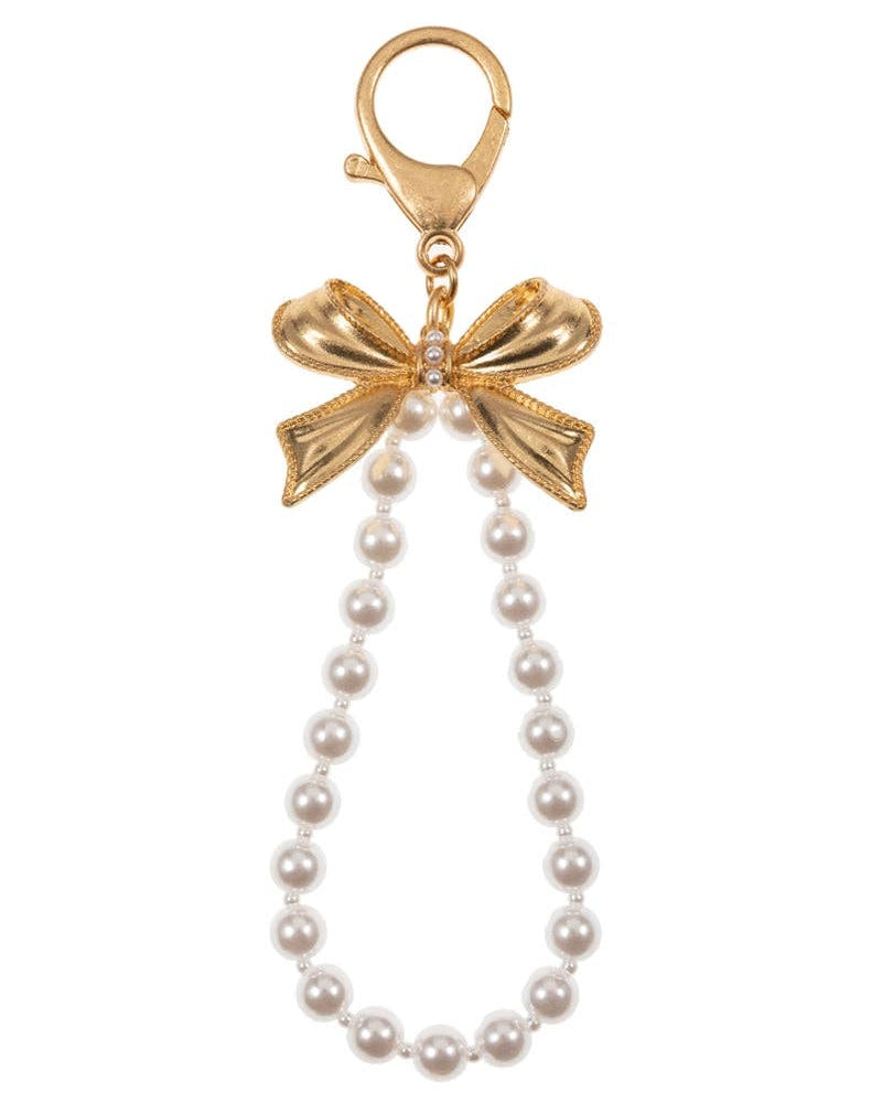 Gold bow charm with pearl necklace on a white background