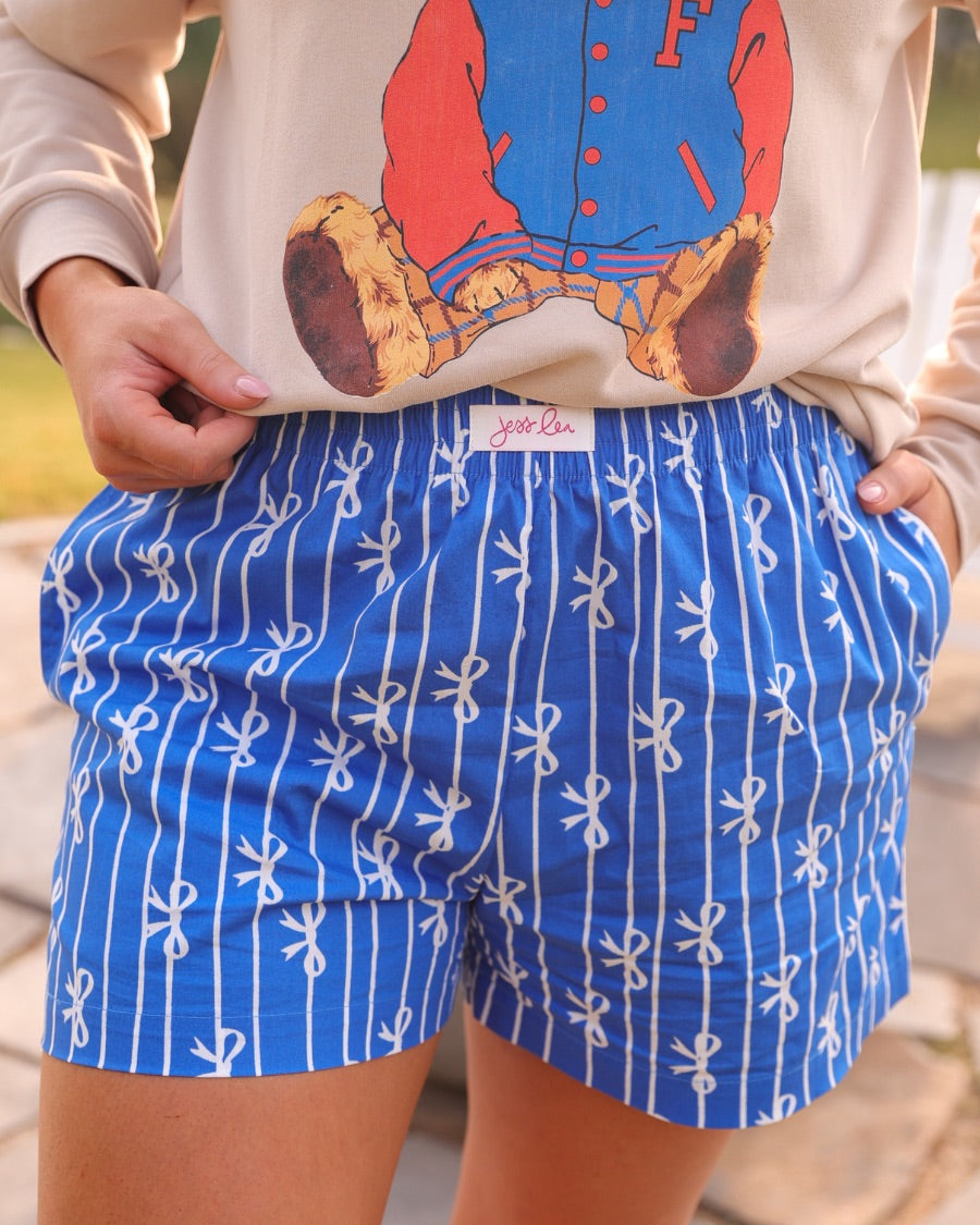 mid-rise relaxed fit boxer shorts with side pockets and an elastic waistband, designed on a bow and stripe pattern print and a solid base in blue