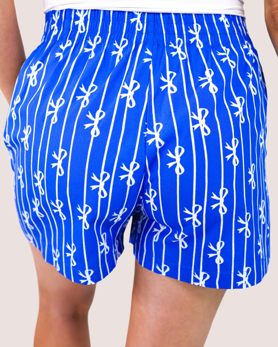 mid-rise relaxed fit boxer shorts with side pockets and an elastic waistband, designed on a bow and stripe pattern print and a solid base in blue