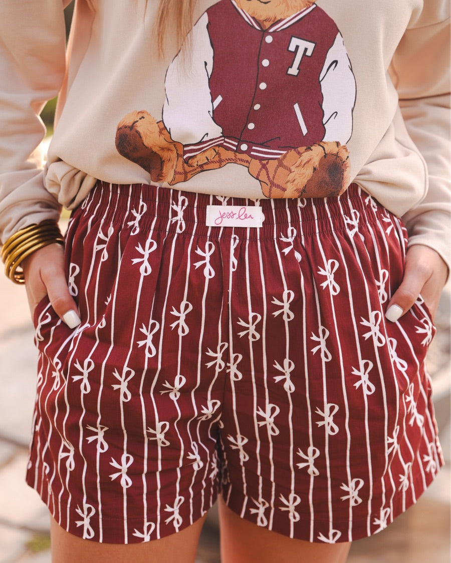 mid-rise relaxed fit boxer shorts with side pockets and an elastic waistband, designed on a bow and stripe pattern print and a solid base in maroon