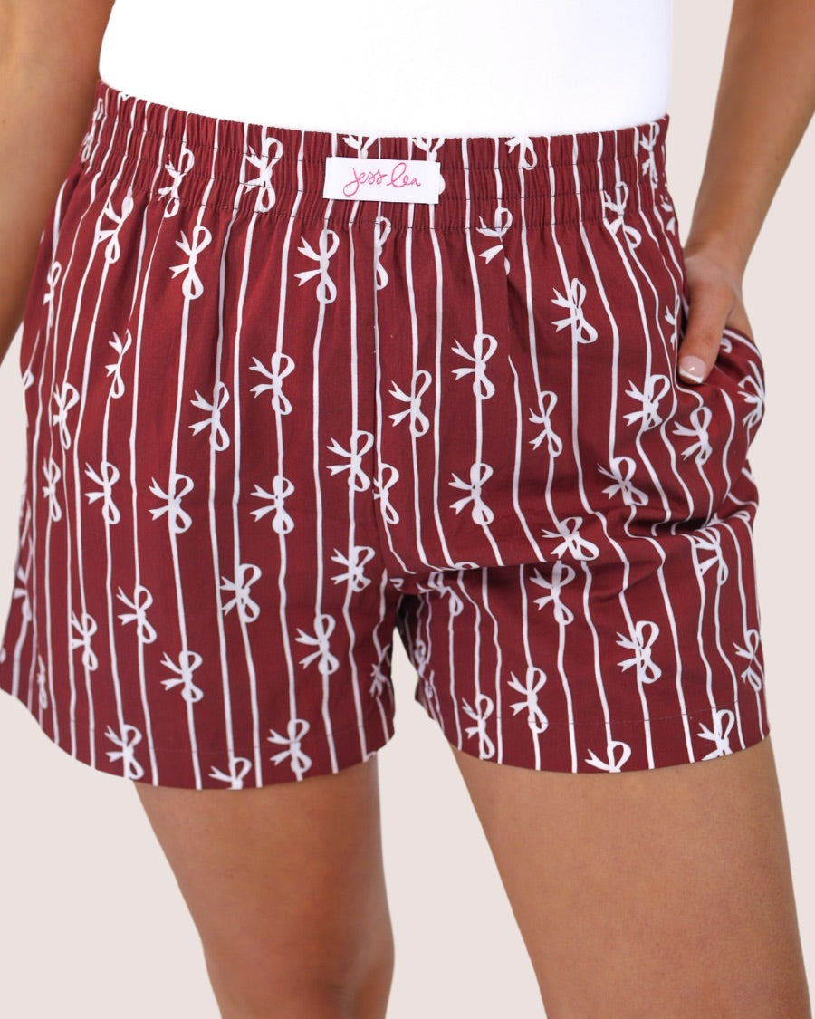 mid-rise relaxed fit boxer shorts with side pockets and an elastic waistband, designed on a bow and stripe pattern print and a solid base in maroon