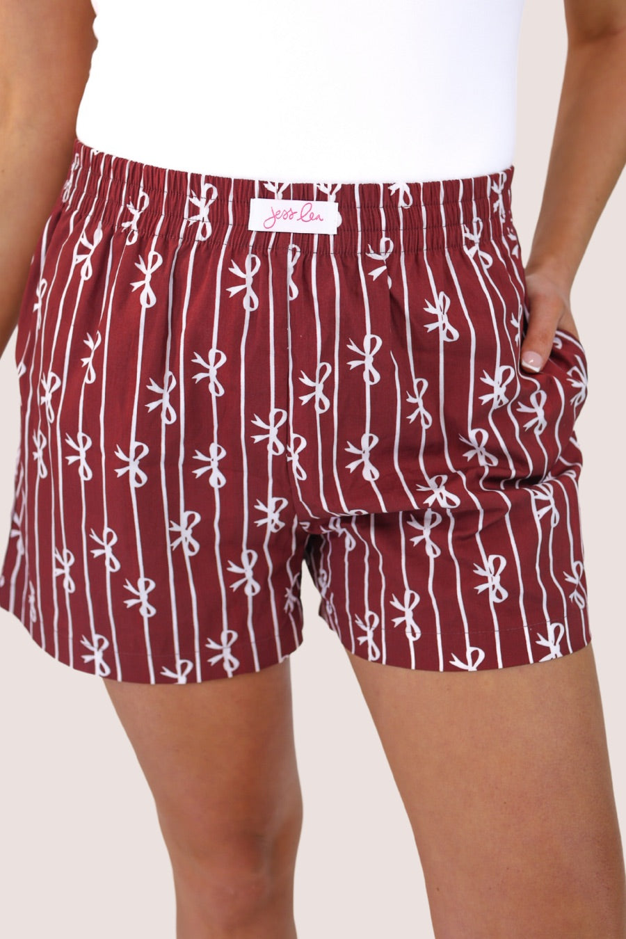 mid-rise relaxed fit boxer shorts with side pockets and an elastic waistband, designed on a bow and stripe pattern print and a solid base in maroon