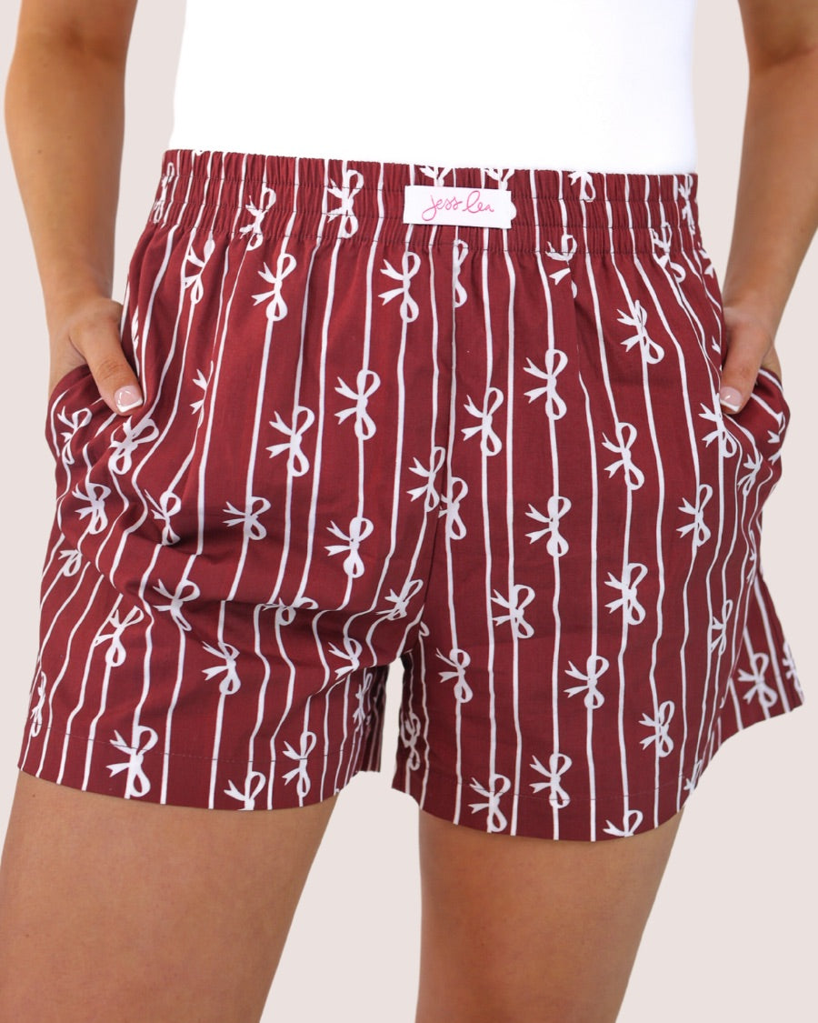 mid-rise relaxed fit boxer shorts with side pockets and an elastic waistband, designed on a bow and stripe pattern print and a solid base in maroon