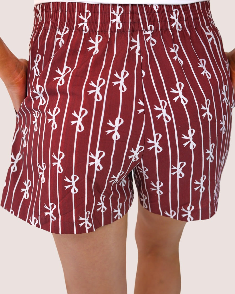 mid-rise relaxed fit boxer shorts with side pockets and an elastic waistband, designed on a bow and stripe pattern print and a solid base in maroon