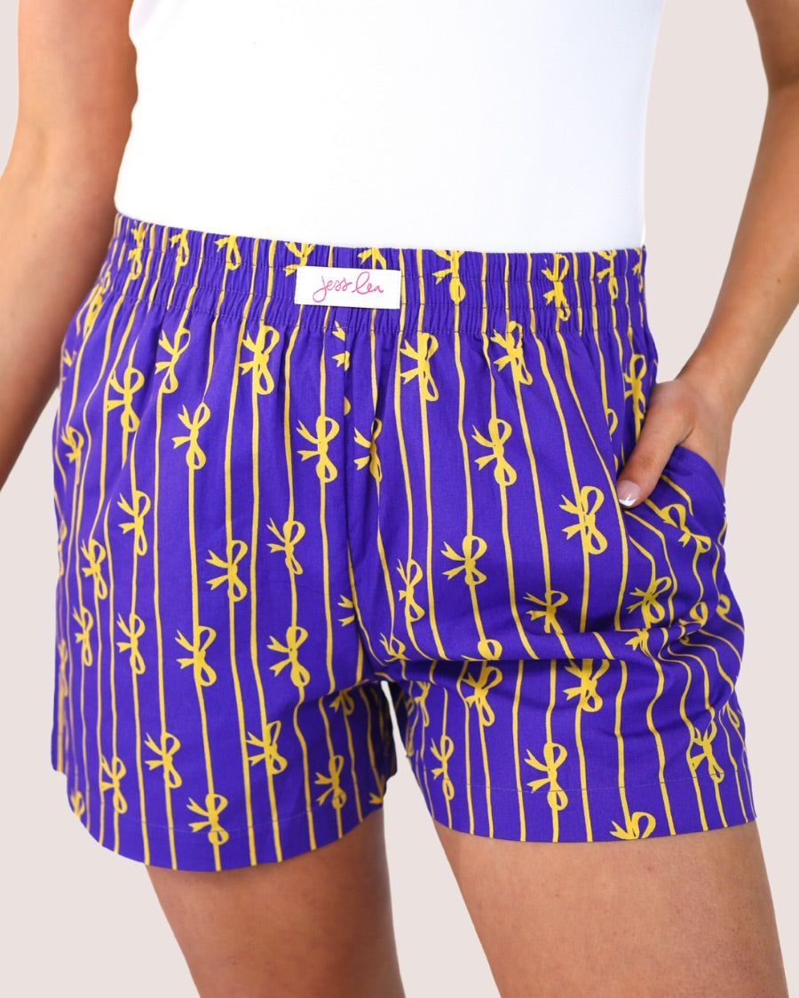 mid-rise relaxed fit boxer shorts with side pockets and an elastic waistband, designed on a bow and stripe pattern print and a solid base in purple