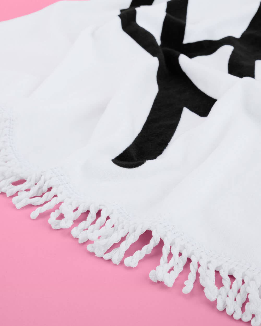 White tassel scarf with black bow on a pink background