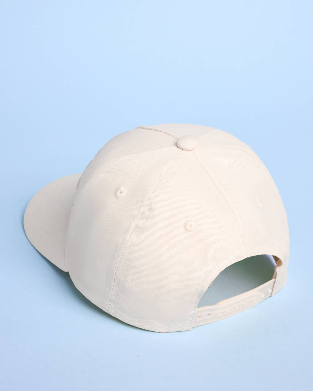 Beige baseball cap on a light blue background