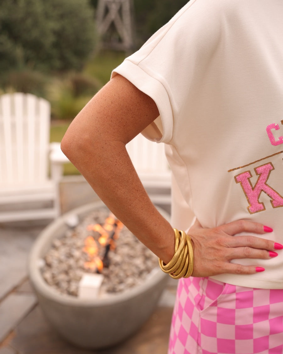 mid-rise relaxed fit everyday skort made of lightweight material with built-in cream shorts, drawstring tie with gold bead accents, an elastic band on the back, and side pockets, designed on a two-tone pink checkered pattern print fabric