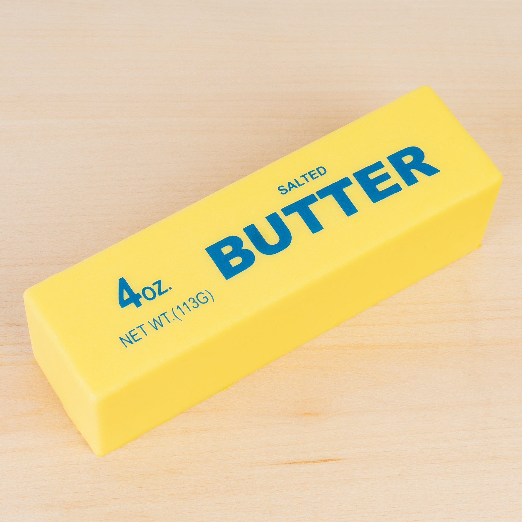 a 4oz yellow butter-stick foam fidget toy made from slow rise polyurethane (PU) foam with a soft texture, classic butter-inspired print, and individual packaging