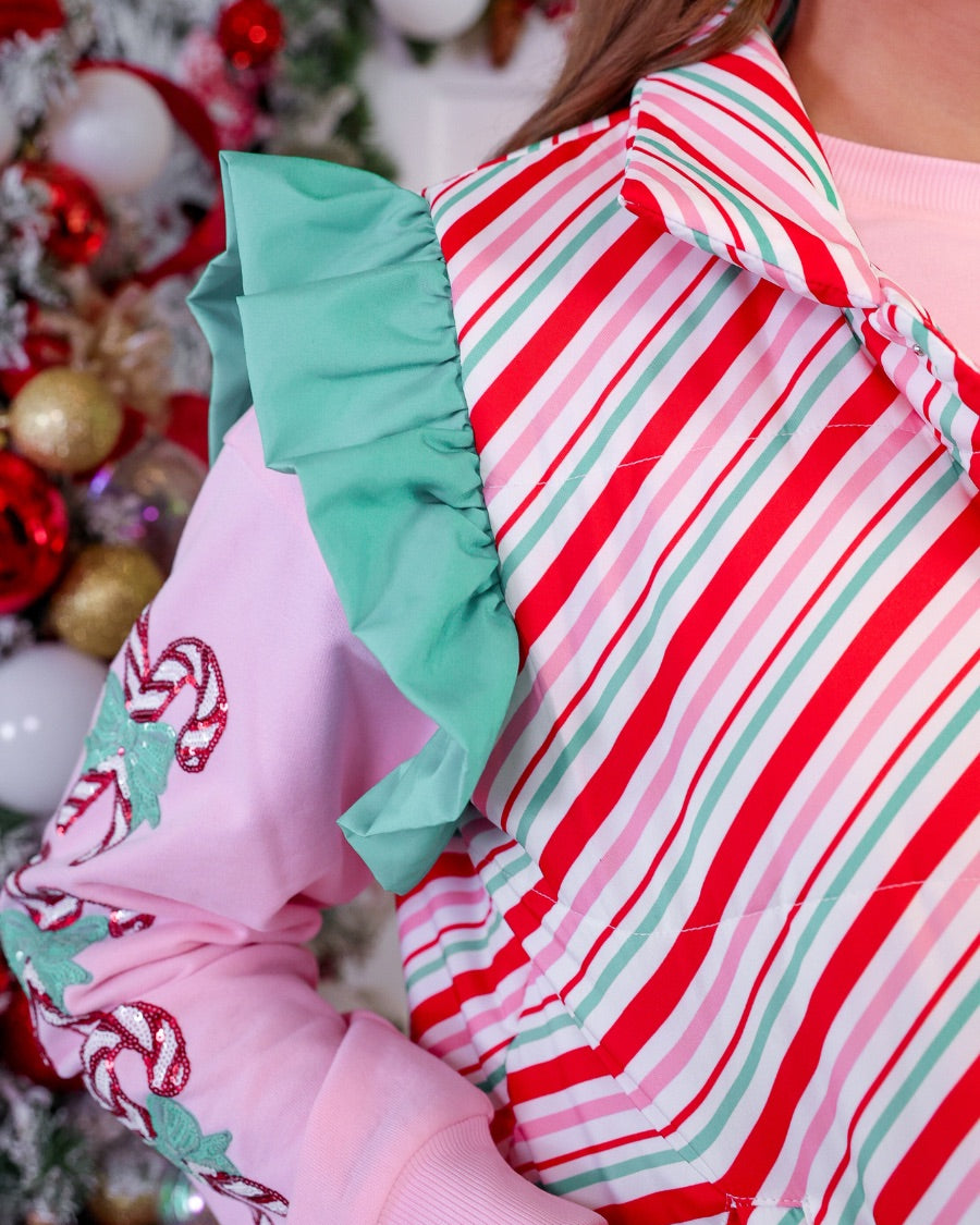 lightweight quilted puffer vest with a festive multicolor candy stripe pattern, snap-front closure, flattering fit, practical pockets, and whimsical teal ruffle shoulder detail