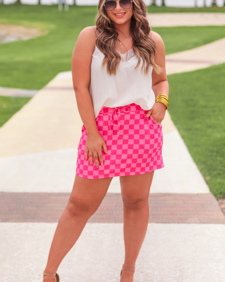 mid-rise relaxed fit everyday skort made of lightweight material with built-in ivory shorts, drawstring tie, an elastic band on the back, and side pockets, designed on a two-tone pink checkered pattern print