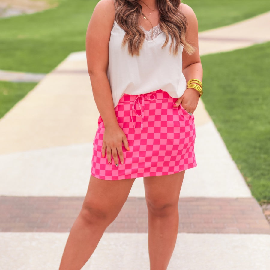 mid-rise relaxed fit everyday skort made of lightweight material with built-in ivory shorts, drawstring tie, an elastic band on the back, and side pockets, designed on a two-tone pink checkered pattern print