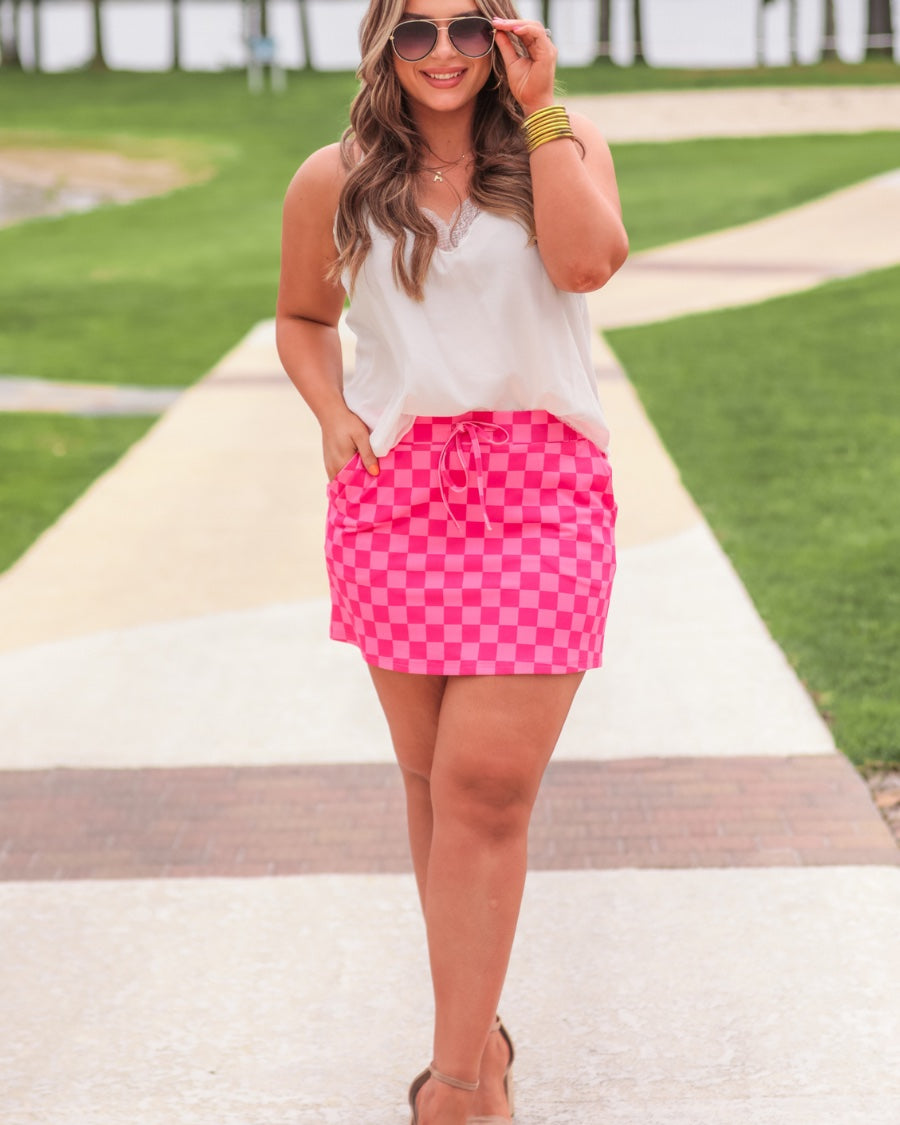 mid-rise relaxed fit everyday skort made of lightweight material with built-in ivory shorts, drawstring tie, an elastic band on the back, and side pockets, designed on a two-tone pink checkered pattern print