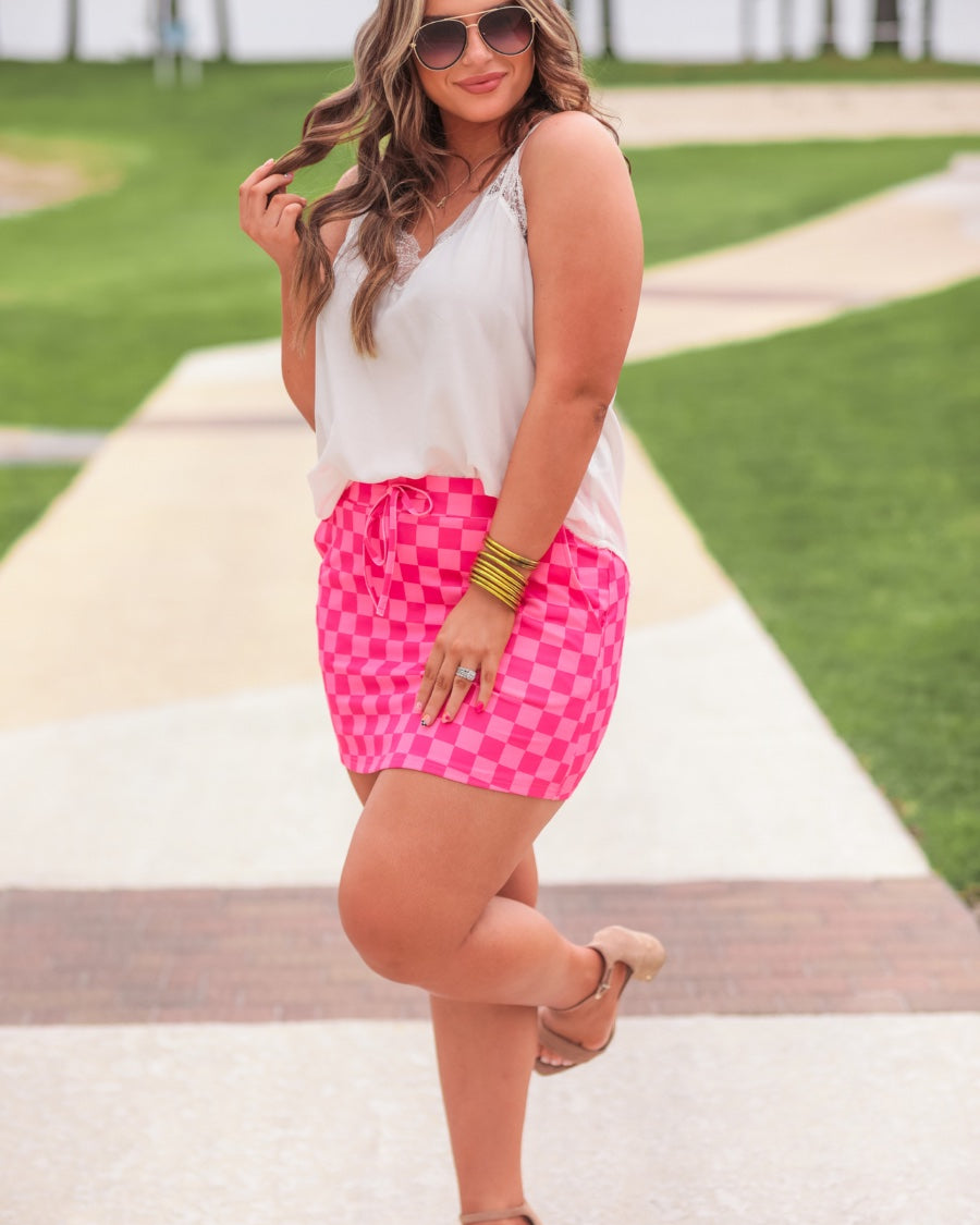 mid-rise relaxed fit everyday skort made of lightweight material with built-in ivory shorts, drawstring tie, an elastic band on the back, and side pockets, designed on a two-tone pink checkered pattern print