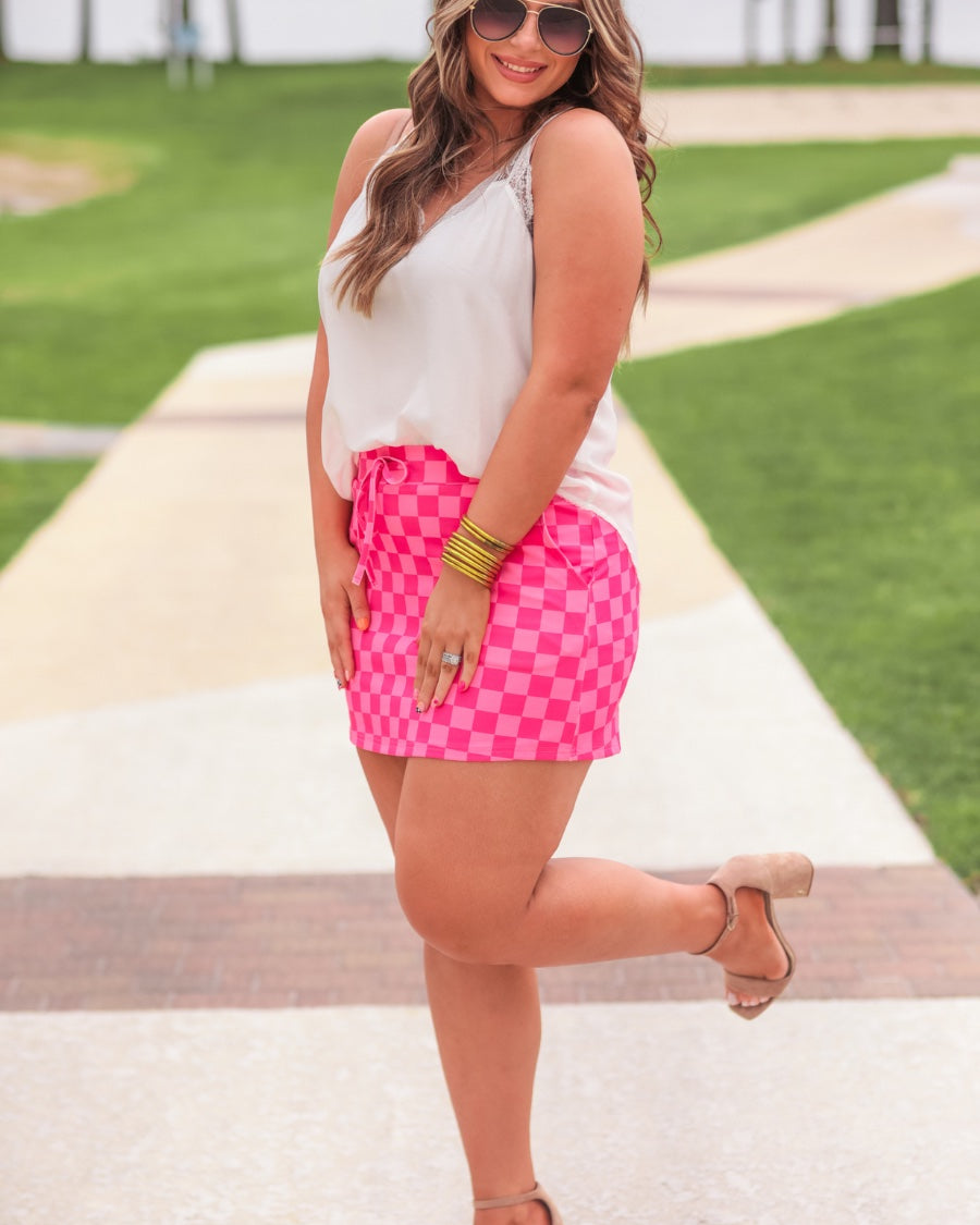 mid-rise relaxed fit everyday skort made of lightweight material with built-in ivory shorts, drawstring tie, an elastic band on the back, and side pockets, designed on a two-tone pink checkered pattern print