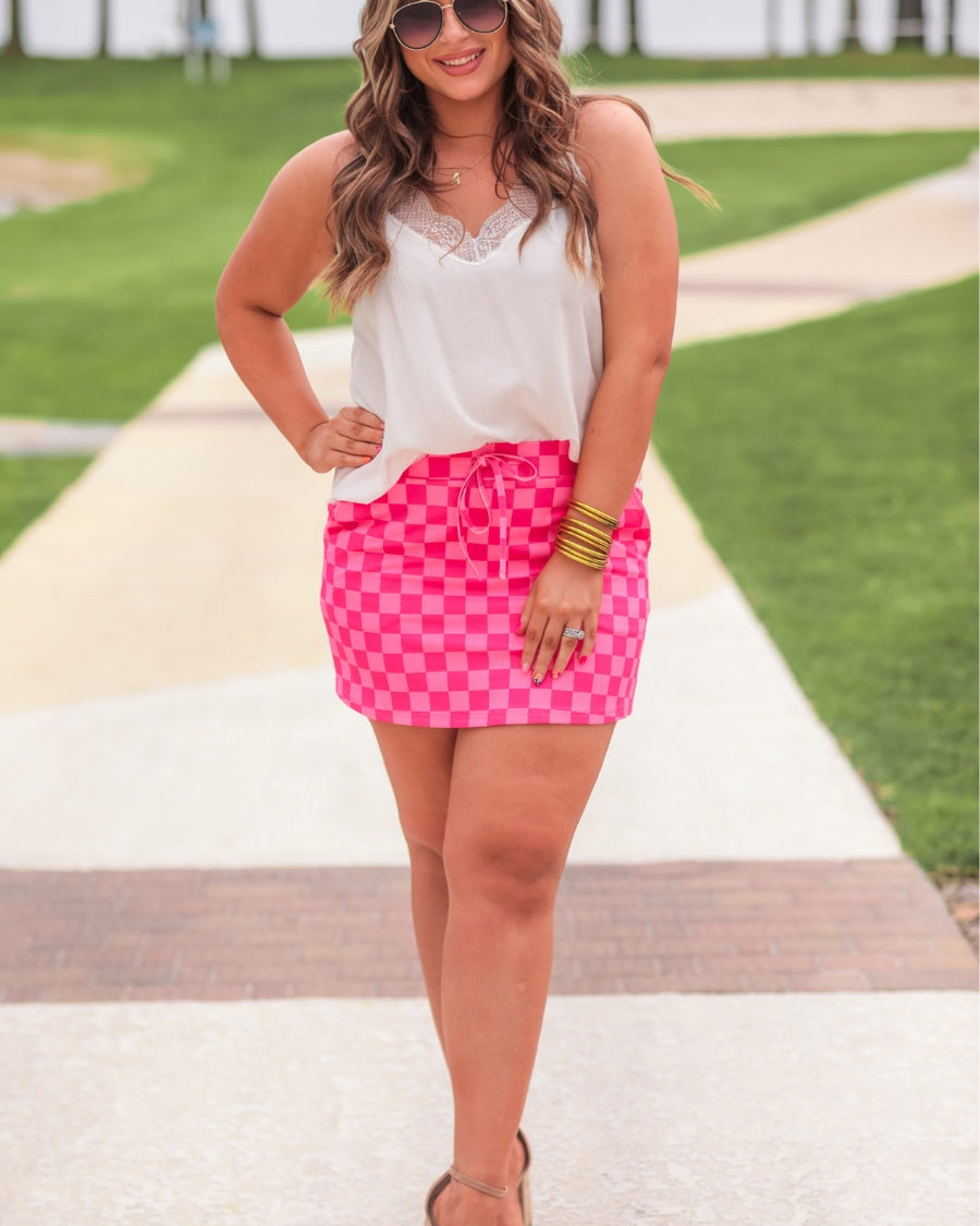 mid-rise relaxed fit everyday skort made of lightweight material with built-in ivory shorts, drawstring tie, an elastic band on the back, and side pockets, designed on a two-tone pink checkered pattern print