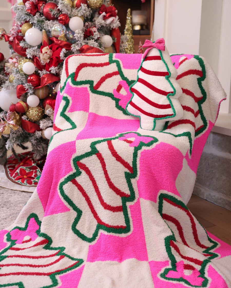 ultra-soft throw on a bold pink and white checkered background decorated with whimsical Christmas tree treats, each topped with an adorable pink bow paired with our Bow Christmas Treat Pillow