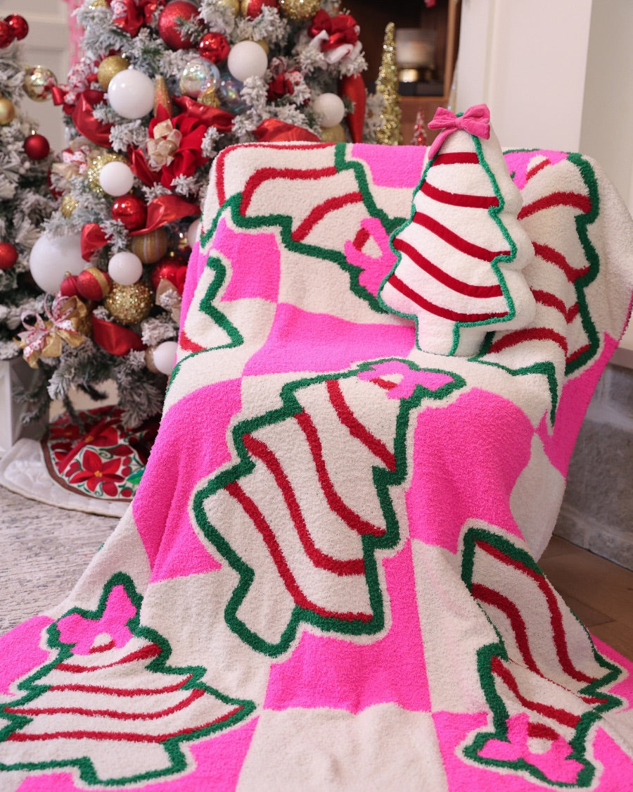 ultra-soft throw on a bold pink and white checkered background decorated with whimsical Christmas tree treats, each topped with an adorable pink bow paired with our Bow Christmas Treat Pillow