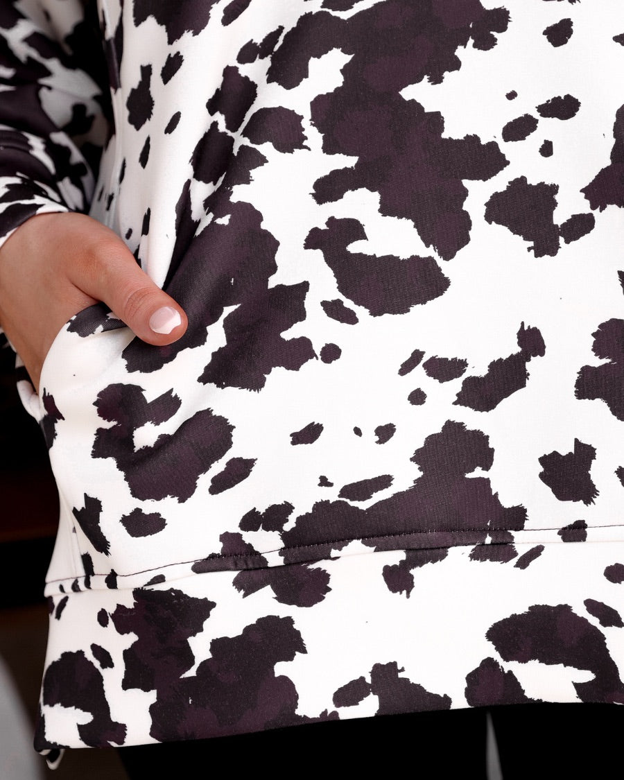 long-sleeve pullover crafted from our best-selling everyday fabric in a bold brown and cream cowhide pattern print, structured collar, functional gold zipper, kangaroo pocket, side slits, and a back yoke seam