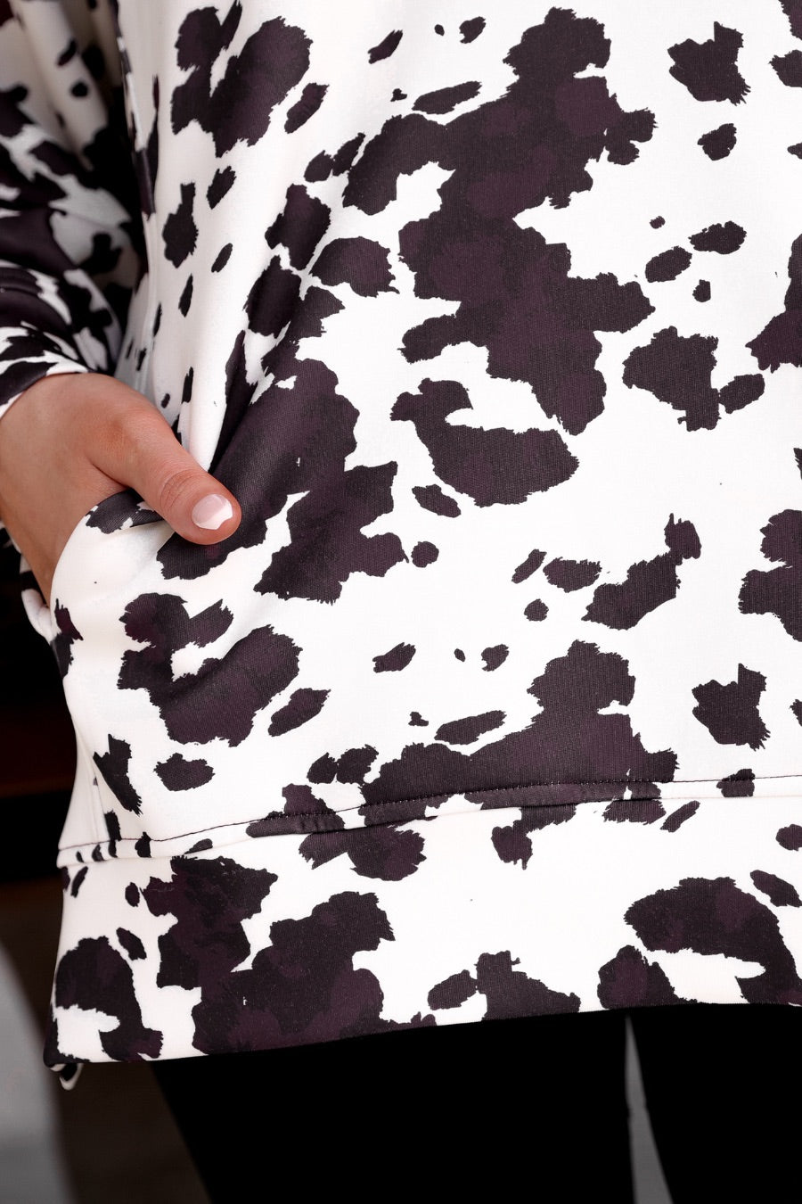 long-sleeve pullover crafted from our best-selling everyday fabric in a bold brown and cream cowhide pattern print, structured collar, functional gold zipper, kangaroo pocket, side slits, and a back yoke seam