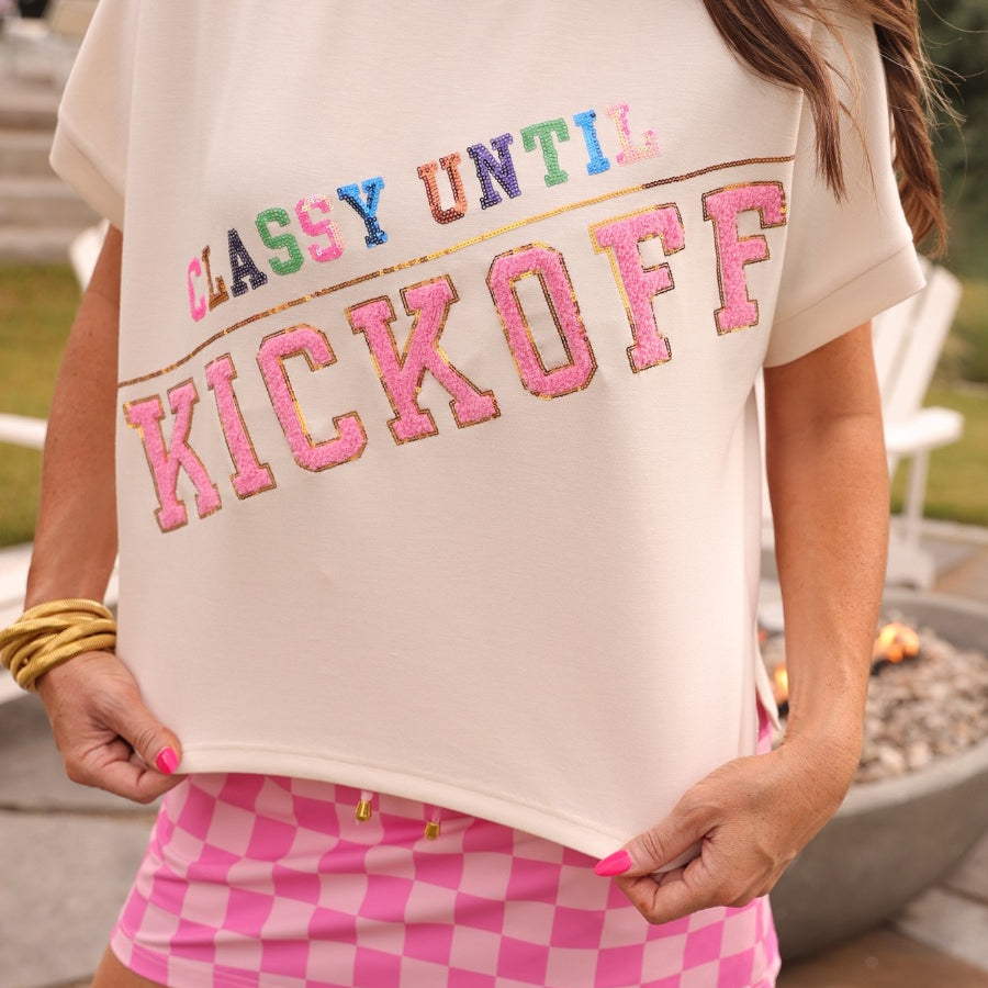 cream short-sleeve mom crop top crafted on a soft, lightweight luxe material with multicolor sequin lettering spelling out CLASSY UNTIL, accented by a gold sequin divider bar, and finished with bold pink chenille KICKOFF lettering outlined in gold sequins