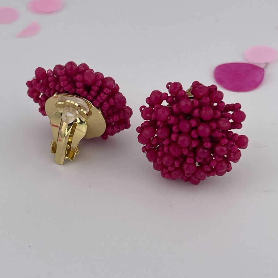 mix of size beads in a pom shape with a clip-on closure