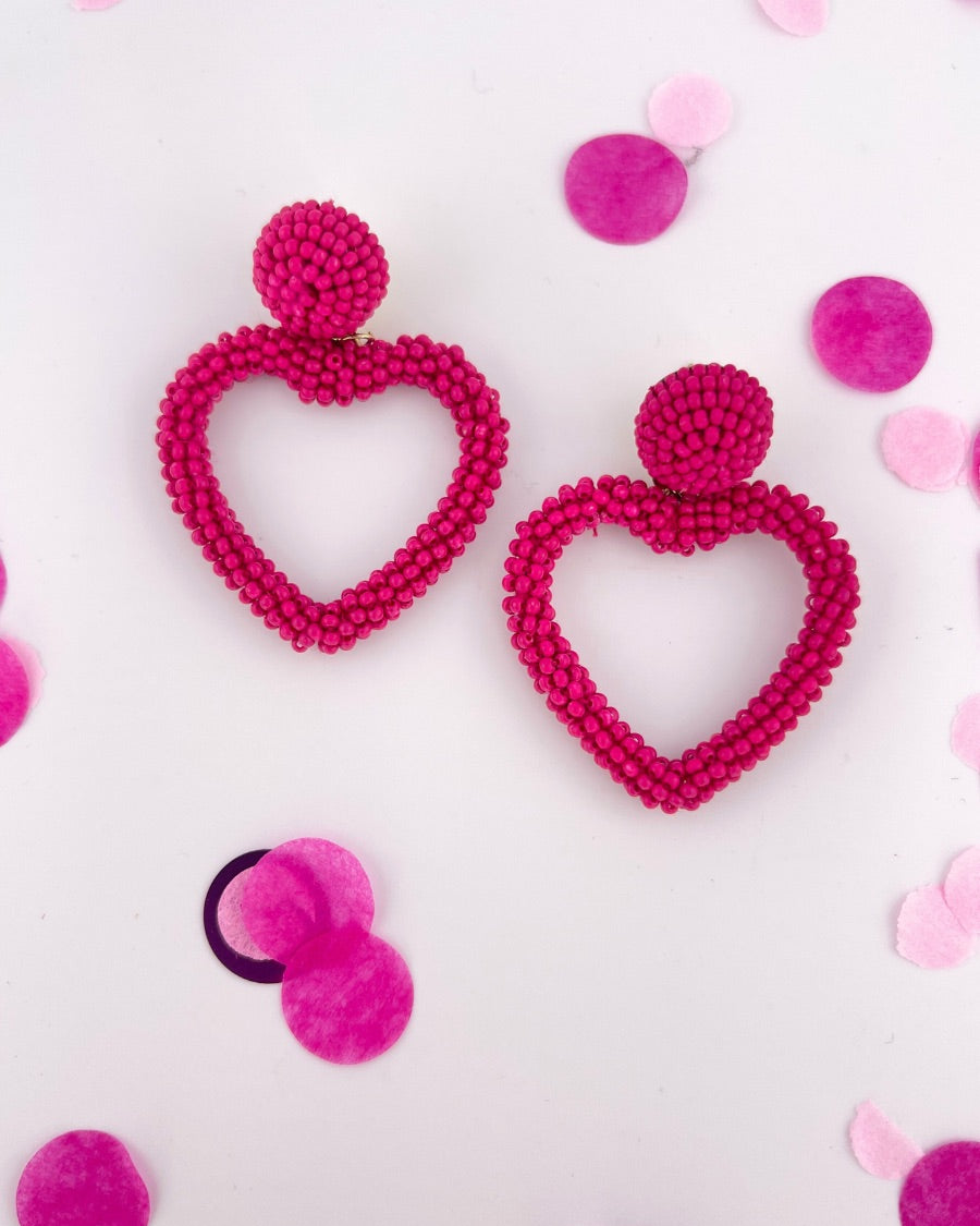 a fuchsia beaded post stud with a matching beaded open heart-shape drop and a comfort earring back in gold