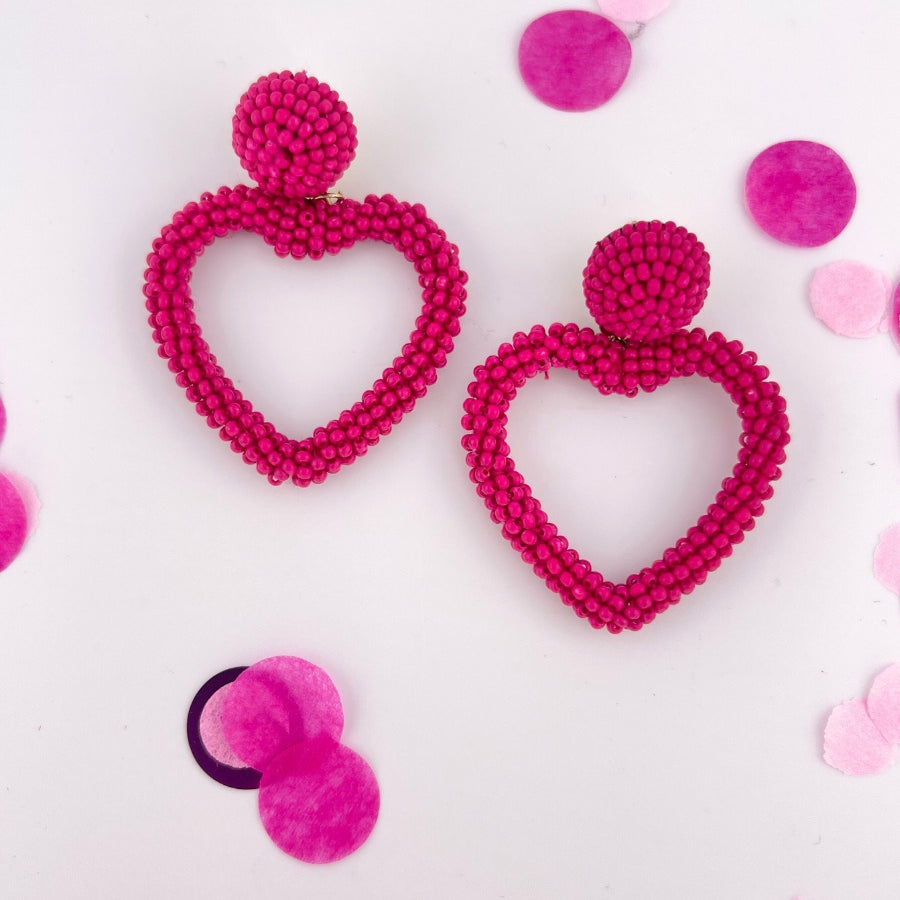 a fuchsia beaded post stud with a matching beaded open heart-shape drop and a comfort earring back in gold